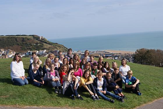 Schulklasse auf einer Wiese am Meer